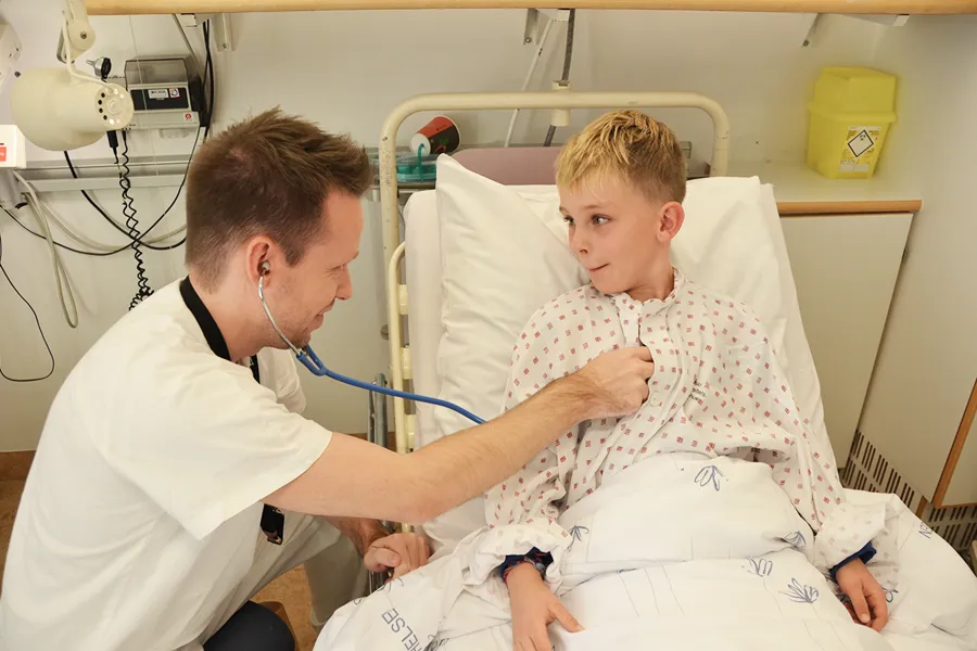 En mann i en sykehusseng med en ung gutt i en sykehusseng